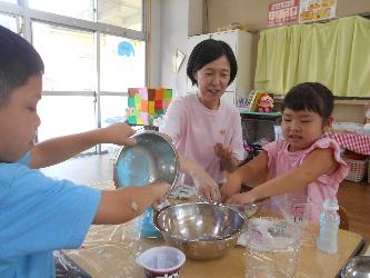 預かり保育員と2人の子どもが遊んでいる