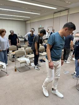 建設事業者である相輪会の従業員が三角巾の取り扱い実技を行っている画像
