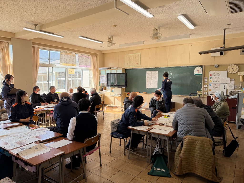 小学校の教室で避難所運営委員が避難所運営訓練に参加している様子