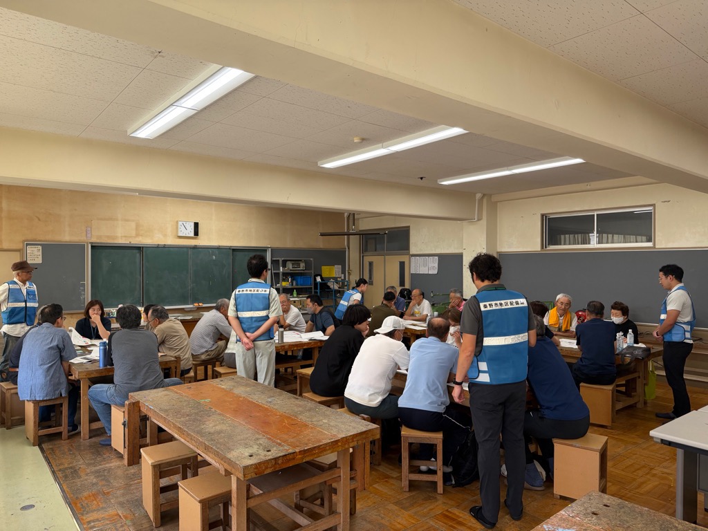 小学校の図工室で避難所運営訓練に参加する参加者の写真