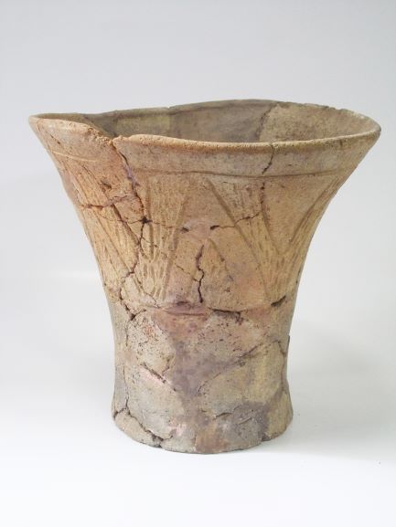 口縁部から底部にかけて広がった深鉢形で、胴部には線刻が施された土器の写真