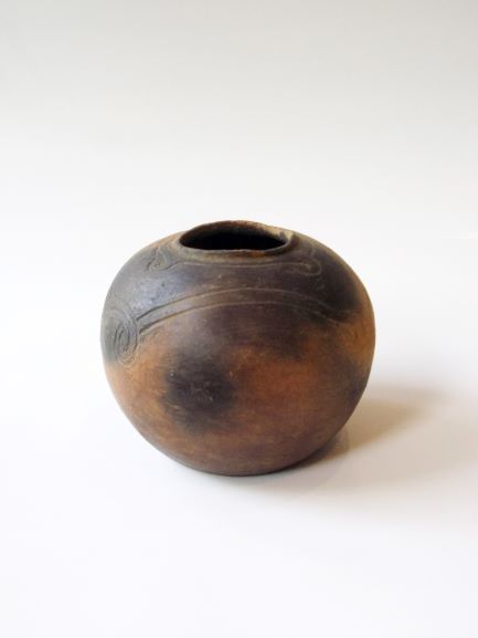 球状の胴体を持つ壺で、胴体に模様が複数施され、全体的に黒く変色した土器の写真