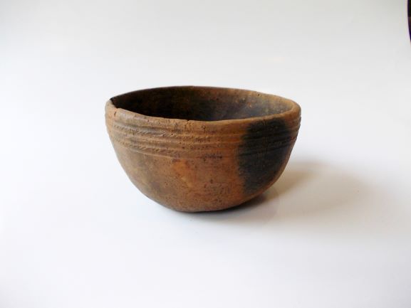 鉢形で、上部の縁に平行な線状の模様が複数刻まれた土器の写真