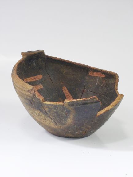 縁の大部分が大きく欠け、表面が黒く変色した鉢形土器の写真