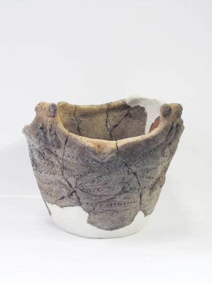 縁が波打った形状で、表面に点線で模様が描かれた深鉢形土器の写真