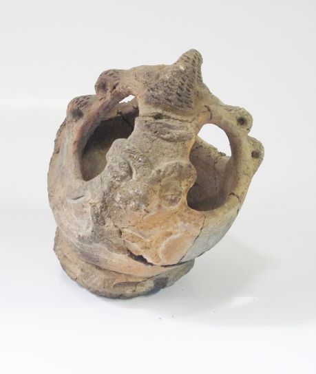 上部の先端が尖った、球体に近い形状で、複数の穴があり、突起や動物のレリーフのような装飾が施された、香炉形土器の写真