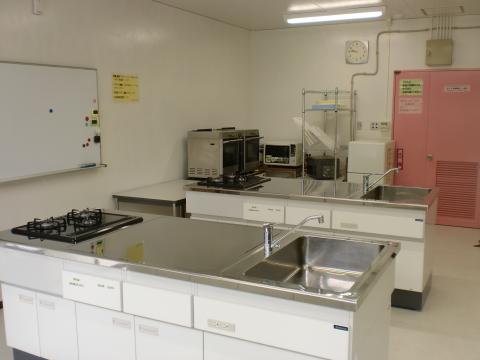 シンク、ガス台、オーブン、冷蔵庫が写っている調理室の写真