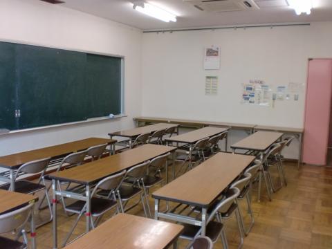 黒板に向かって長机が数脚並べられた学習室の写真