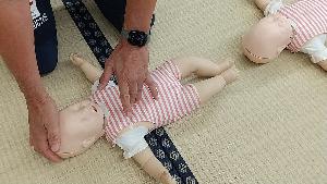 幼児の人形で心臓マッサージの実習をしている様子