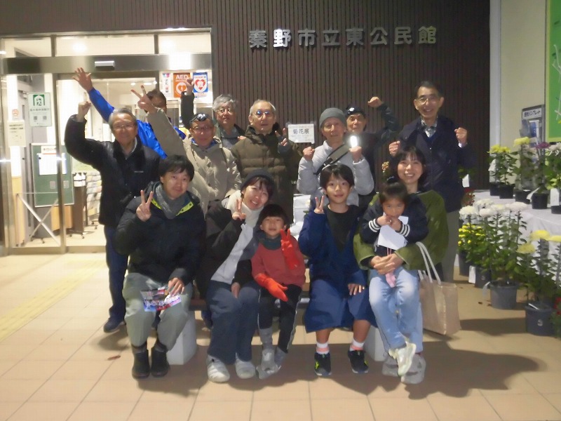 子供から大人まで様々な年齢層の人々が笑顔でカメラにポーズをとっている、参加者たちの集合写真