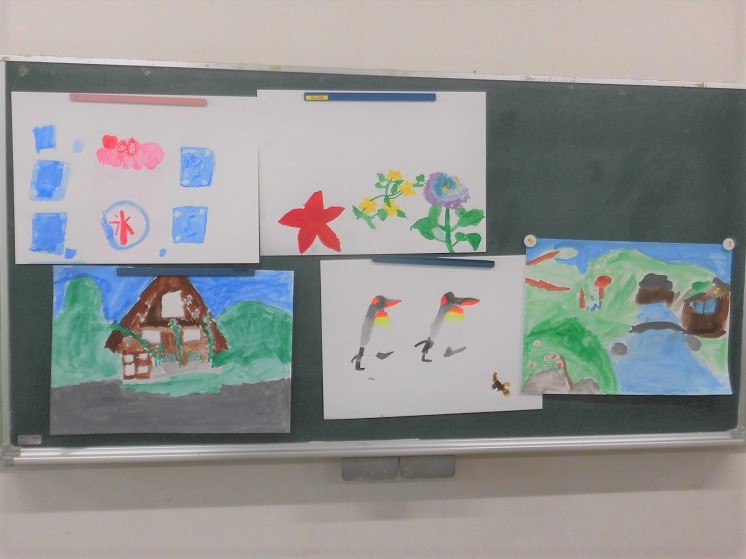 黒板に、家、ペンギン、花、氷など5枚の絵が掲示されている写真