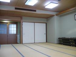 畳が広がった和室で、正面奥に白い襖が2枚、左奥には木枠の障子戸のような引き戸がある室内の写真