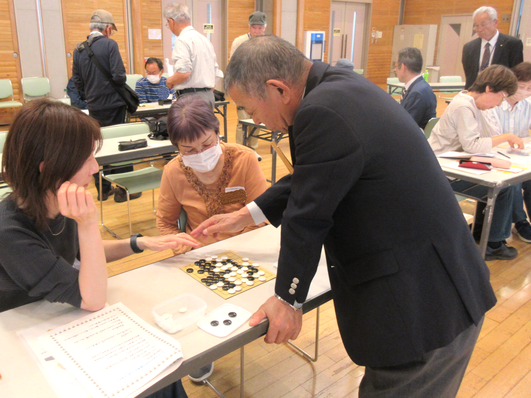 秦野囲碁同好会さんによる対局結果の解説を受ける参加者