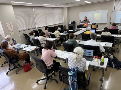 机を並べたところに10人ほどの人が座り講習を受けている