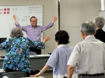 講師が両手をあげて体操をしている