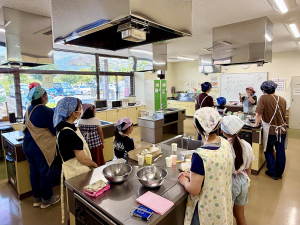 調理室で親子で講師の説明を聞いている