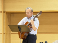 ギターの弾き語りをする講師