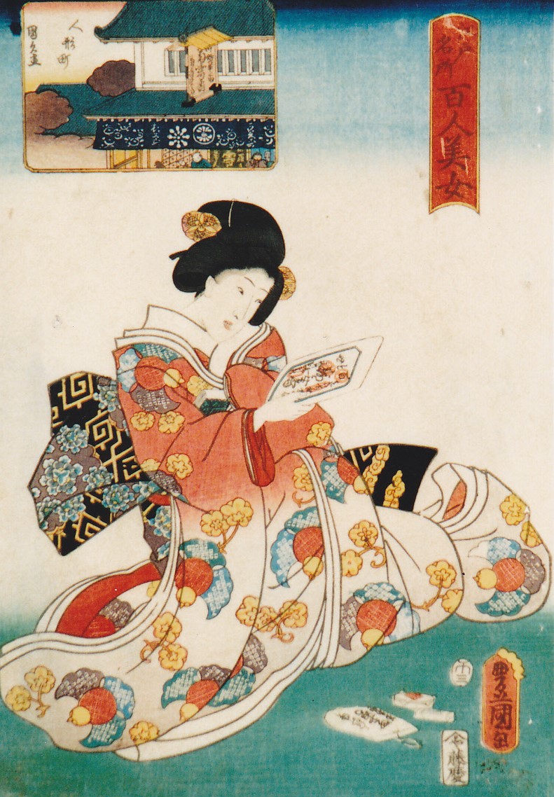 背景には屋敷の小さな絵が添えられ、黒髪にはかんざしが挿されていて、下が白地で上がオレンジ色地で花柄の着物を着た女性が、畳の上に座って右手に絵が描かれた紙を持って見ている様子を描いた浮世絵