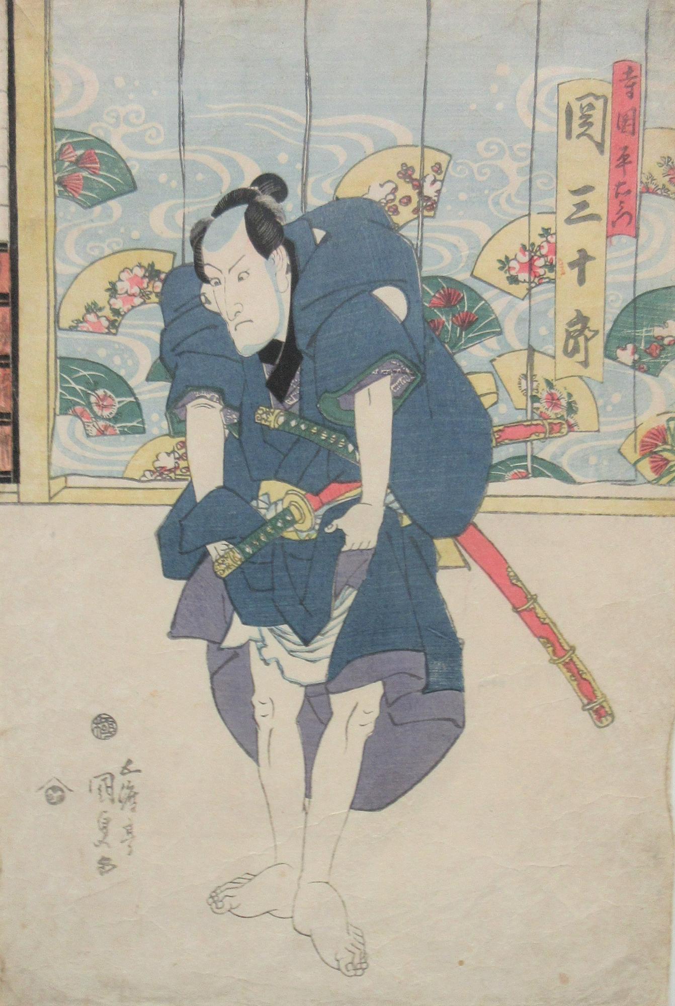 薄い黄色と緑色の扇が描かれた着物がかけられた前で、帯に二本の刀を差した裸足の男性が青い着物をまくり上げ、何かを企むような表情で少し前かがみの姿勢を見せて立っている歌舞伎役者の浮世絵