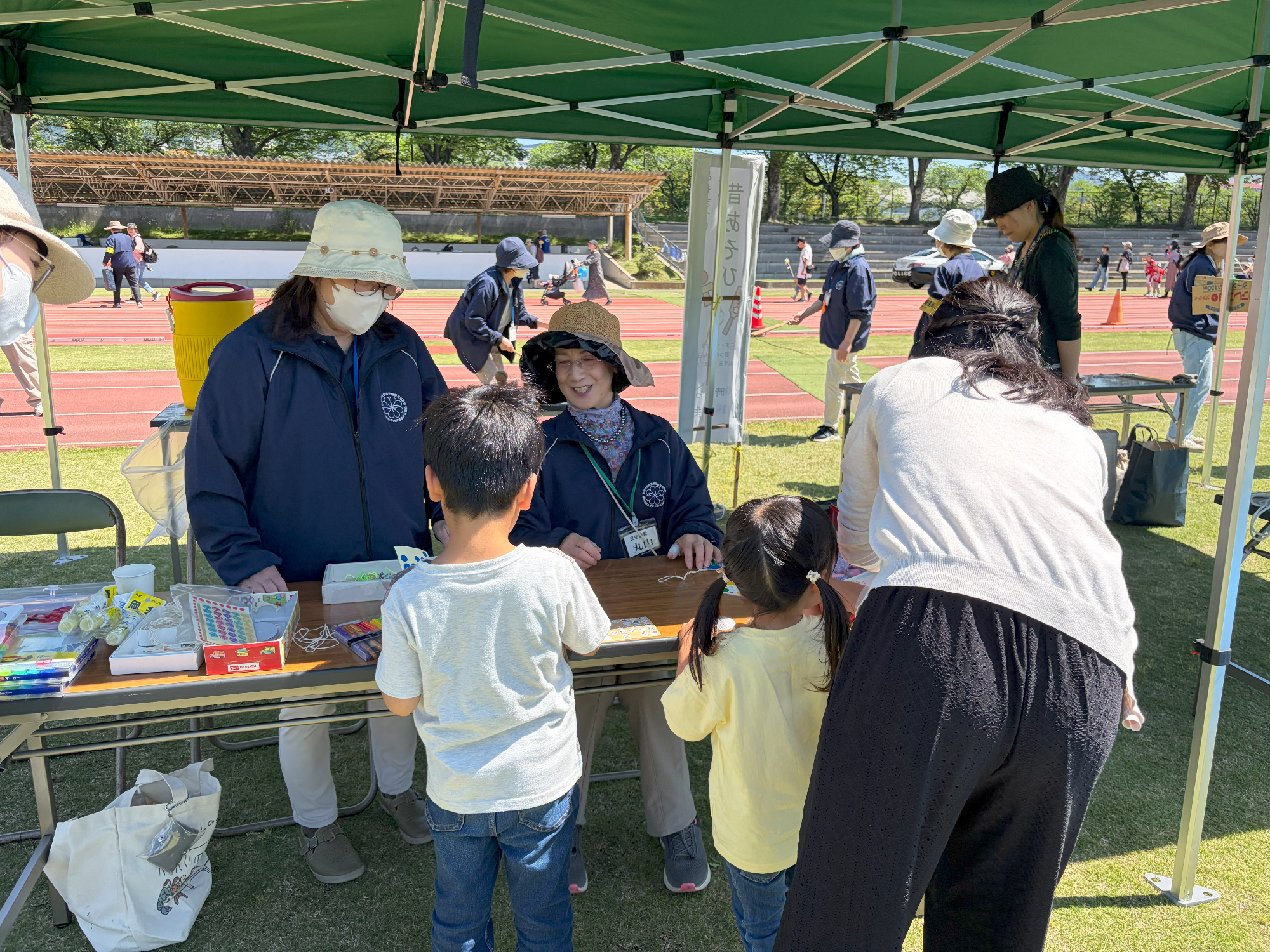 民生委員がぶんぶんごまを一緒に作成する様子