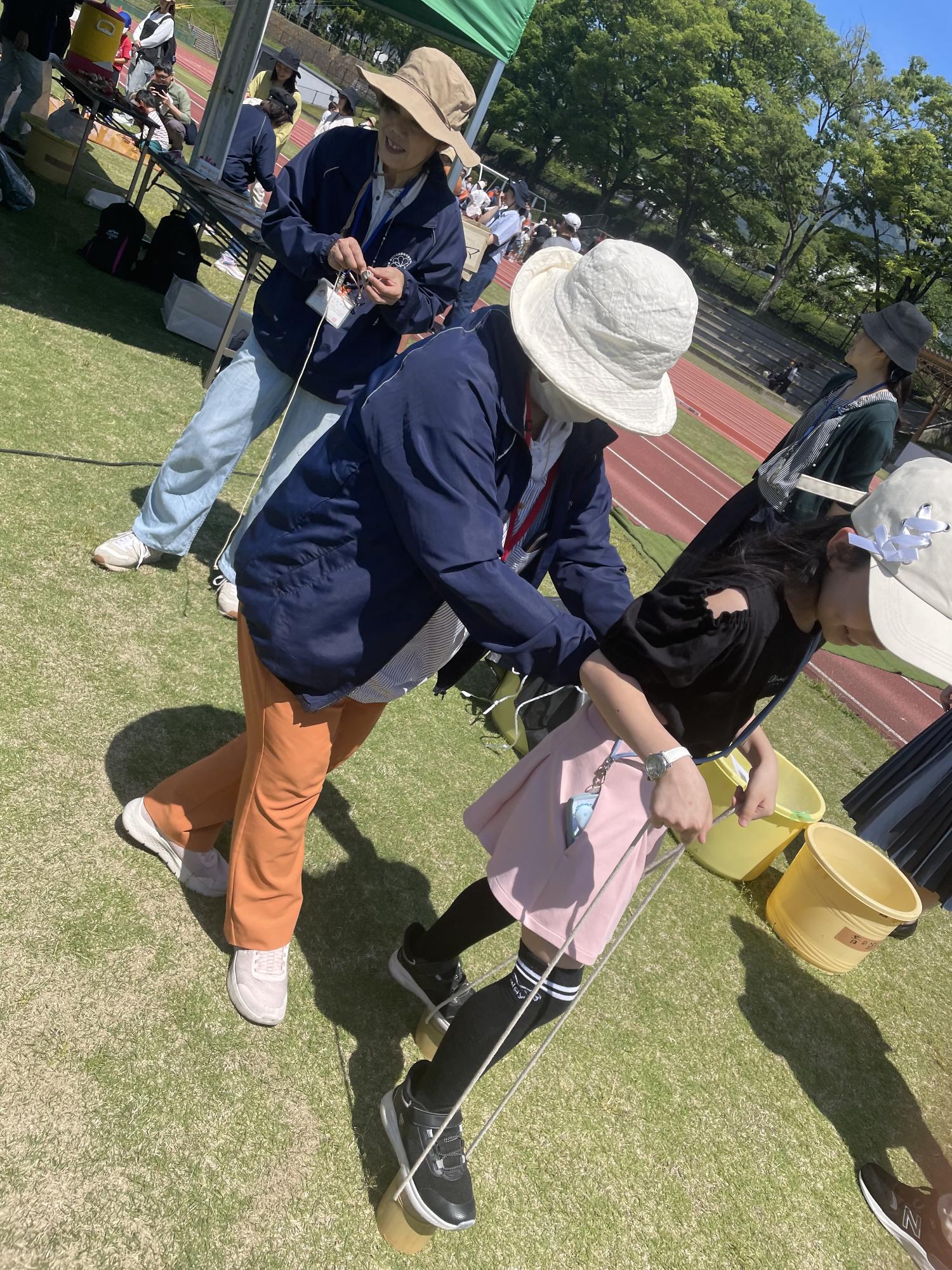 竹馬を教える民生委員とこども