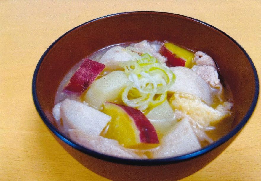 皮付きのさつまいもと白い根菜や肉などの具材がゴロゴロ入った豚汁がお椀に注がれた写真