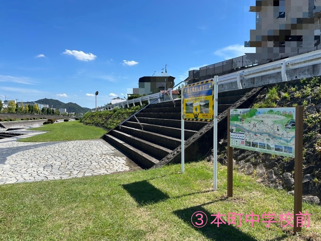 土手にある階段の横に設置されている本町中学校前のウォーキング看板を写した写真