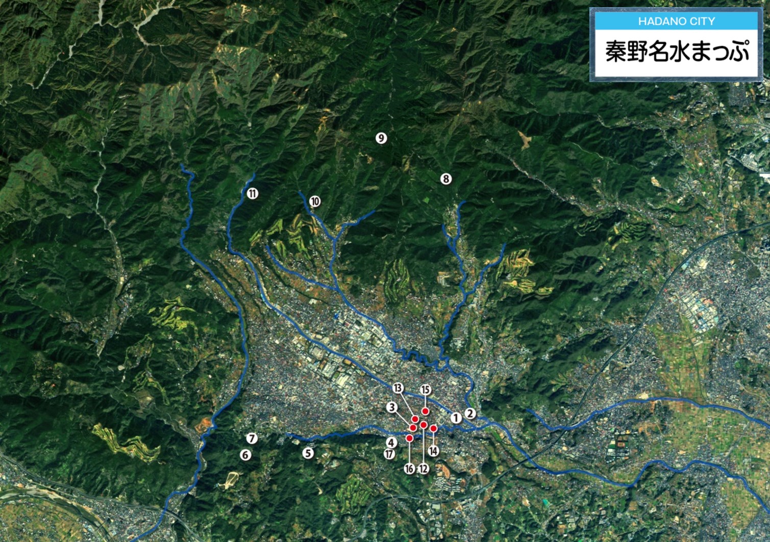市街地を囲む山脈の間を流れる川と、周辺に1から17までの数字が記された、右上に「秦野名水まっぷ」と表示された立体模型の写真