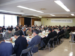 広い会議室で多数の関係者の方々が並べられた机に座り資料を広げ目を通している第61回全国植樹祭秦野市民推進会議の様子を写した写真
