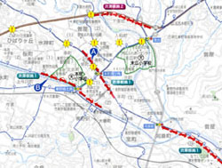 地域周辺の道路と地名が描かれた地図上に、二つのバイパス計画ルートが赤い破線で示されており、主要地方道と交差する地点には黄色の「!」マークが付いており、既存の小学校の場所が緑色の囲みで示されたルート図