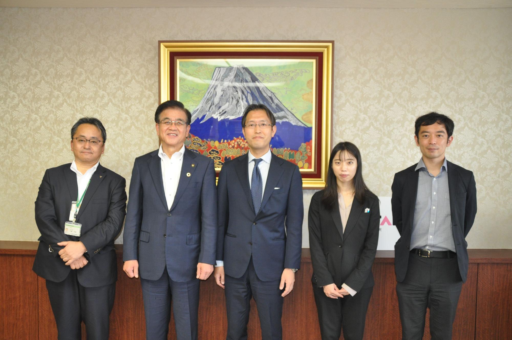 高橋市長と文部科学省・地方教育アドバイザーの方4名と並んで立ち、記念撮影を行っている写真