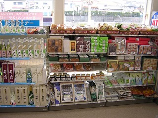 陳列棚に、左側から日本酒などの箱や瓶、中央に菓子やジャムの箱、右側には乾麺や茶葉などが陳列されている名産品コーナーの写真