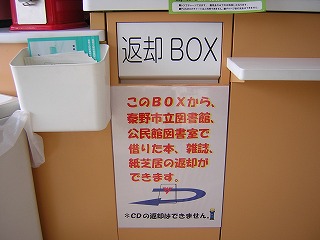 店内に設置された「返却BOX」の文字が書かれ、下に注意書きが貼られた返却ポストの写真