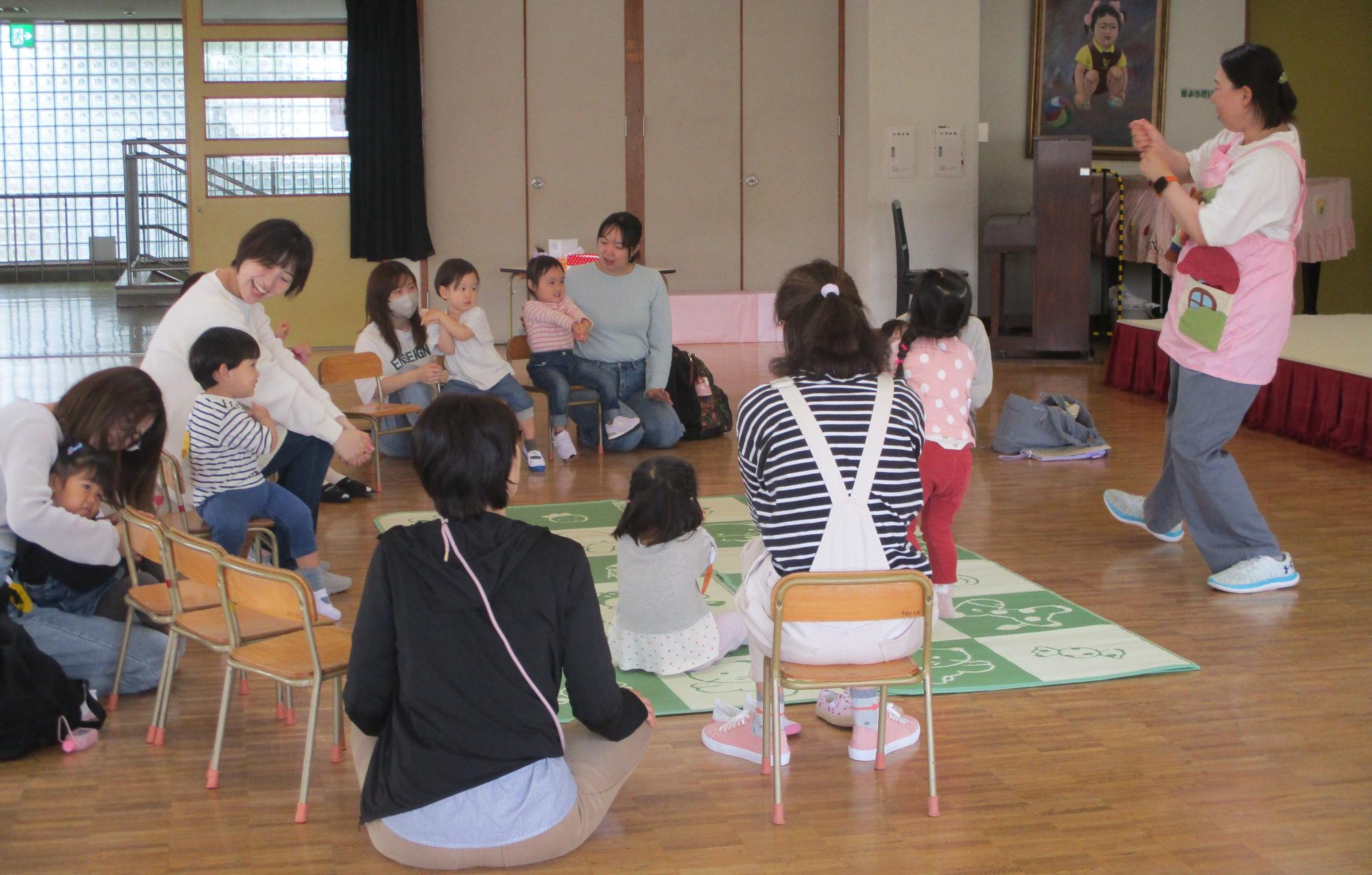 先生がエプロンを使って大きなかぶのお話遊びをしているところです。