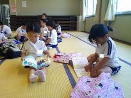 南公民館のt所室で借りた絵本や図鑑を和室で読んでいる