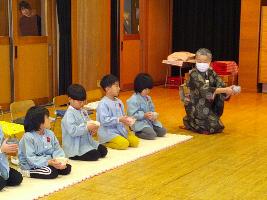 和装姿の講師の先生と一緒に年長児が正座をしてお茶会に参加