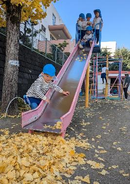 すべり台のところでいちょうの落ち葉で遊ぶ