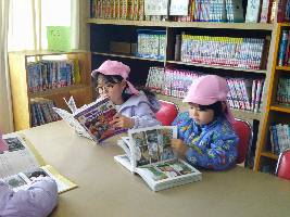 隣接する南小学校の図書室を見学し、好きな本を見つけて真剣な表情の年長児