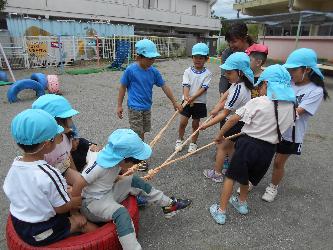 タイヤに乗ったり、タイヤを引いたりして遊ぶ子ども達
