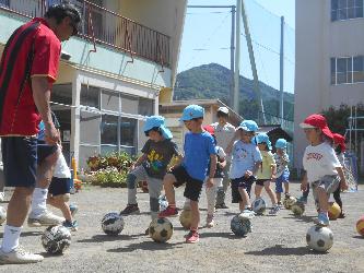 サッカーコーチによる指導を受けている子ども達