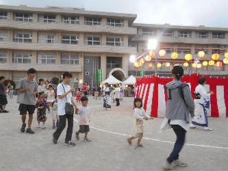 親子で納涼大会に参加し、地域の方と盆踊りを踊っている
