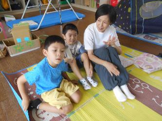 預かり保育員と子ども達が笑顔で会話をしている