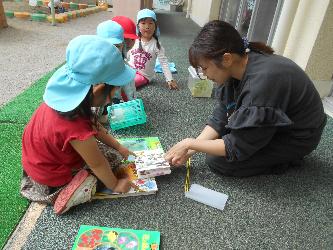 先生と子ども達が図鑑で調べている