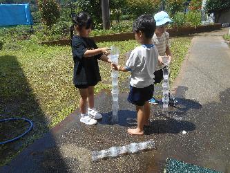水遊びをしながら水の不思議さを繰り返し試している子ども達