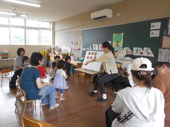 未就園児親子が幼稚園でパネルシアターを見ている