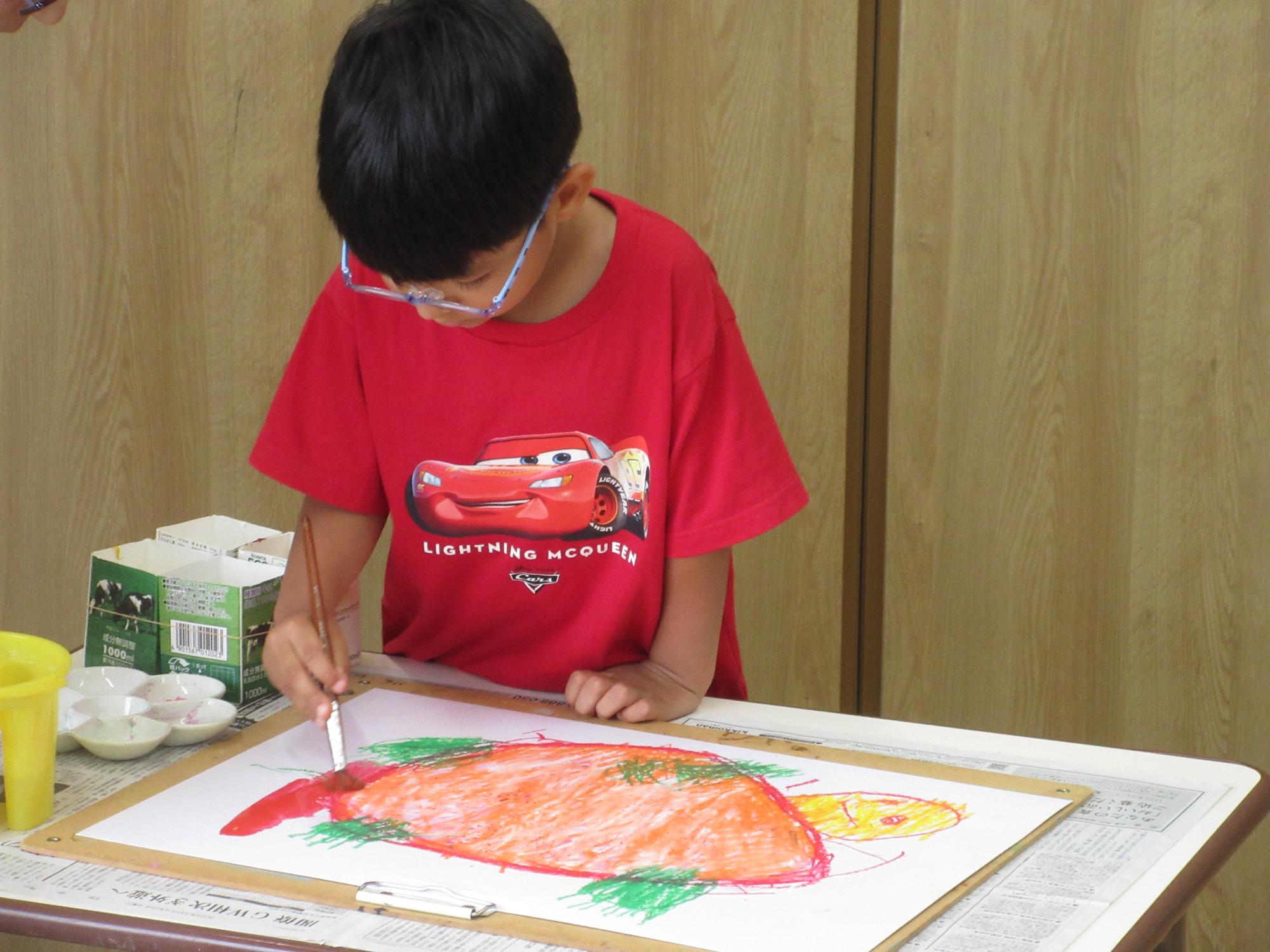 絵画指導でカメを描き、絵具で色を塗っている