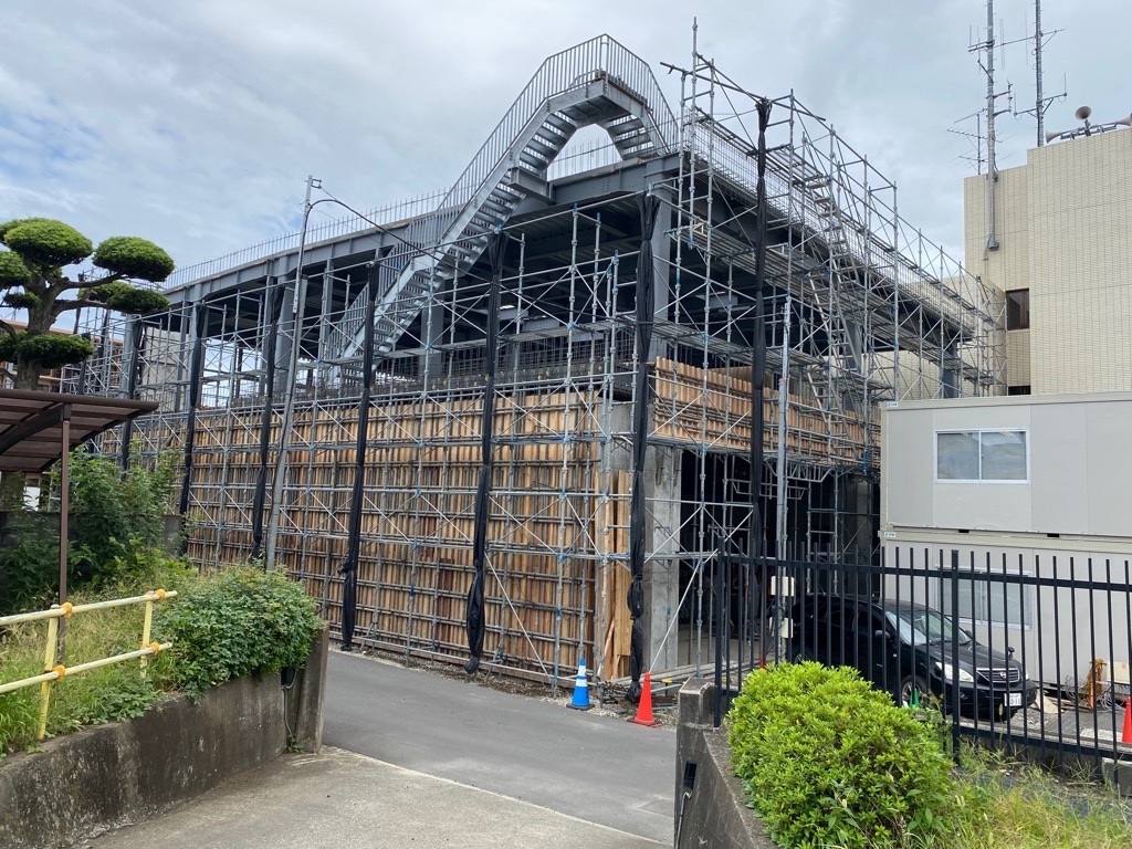 複数の工事用足場と、型枠が組まれている建設中の消防署の外観の写真