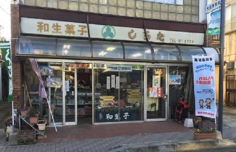 「和生菓子 しろた」という看板を掲げた昔ながらの和菓子屋の店先に、秦野市消防団サポートショップののぼり旗が立てられている様子の写真