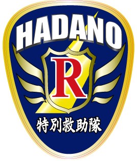 濃紺のシールド型をベースに、上部に白色の「HADANO」、下部に「特別救助隊」の文字、中央に稲妻を背景にした赤い「R」の文字と金色に輝く翼がデザインされた新ワッペンのイラスト