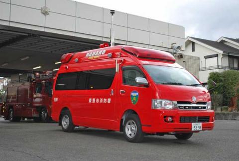 赤色のワゴンタイプの車両で、側面に「秦野市消防署」と書かれ、上部には赤色灯や無線機器が装備されており、消防指令車として使用されている秦野市消防の消防署本署の指揮車の写真